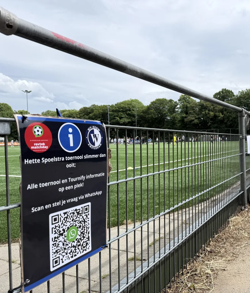 QR-bord van Revtek Matchday langs het speelveld bij WV-HEDW Amsterdam